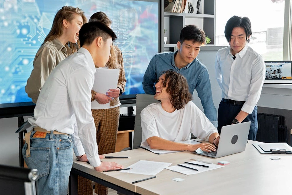 Team diversificato e collaborativo che lavora in un moderno ufficio open space.